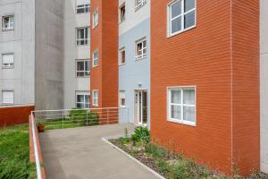 ein orangefarbenes und weißes Gebäude mit Bürgersteig daneben in der Unterkunft Urbanização Casas Do Lago, Serra de Carnaxide in Amadora