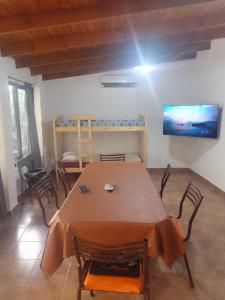 Una habitación con una mesa y sillas y un televisor. en Casa quinta barrio real, en Junín