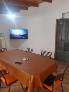 mesa con sillas y TV en la pared en Casa quinta barrio real, en Junín 20 fotos más
