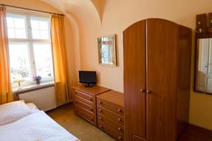 a bedroom with a bed and a dresser with a television on it at Retro Willa Jemioła Centrum in Karpacz