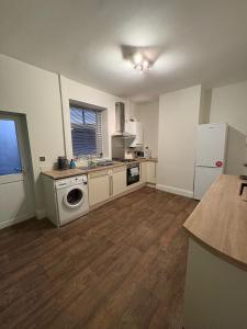 a kitchen with a stove and a sink and a refrigerator at 2 Bedroom House for Contractors in Oswaldtwistle