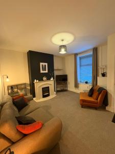 a living room with a couch and a fireplace at 2 Bedroom House for Contractors in Oswaldtwistle