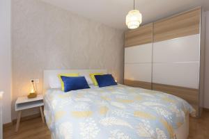 Un dormitorio con una cama con almohadas azules y amarillas. en Casa Real by BeValle, en Escarrilla