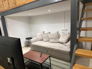 a living room with a couch and a tv at Kerem-market Studio 1 in Tel Aviv