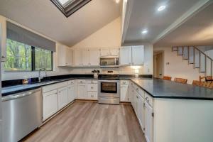 a kitchen with white cabinets and black counter tops at Secluded Retreat w Hot Tub, FirePit & Pool Access in Hedgesville