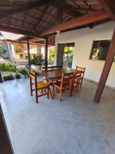 a wooden table and chairs on a patio at Casa com Piscina em Búzios in Buzios