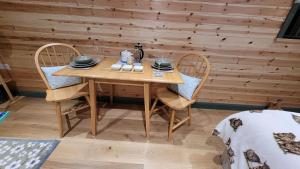a wooden table and two chairs with plates and dishes on it at Cater Tober Haven in Wick