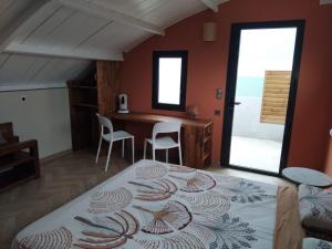 una camera da letto con un letto, un tavolo e delle sedie di Mon Ti Kaz Canot a Petite-Île