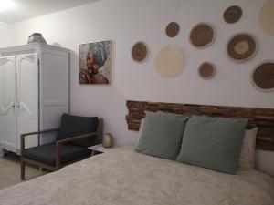 a bedroom with a bed and a chair and plates on the wall at Nature et bien- être in Sauvigney-lès-Pesmes +15 photos