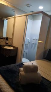 a room with a bed and a bathroom with a sink at Hotel Aero Sleep Campinas in Campinas