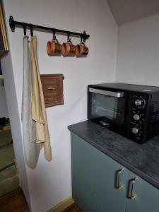 a kitchen with a microwave and a counter with towels at Stædets lejlighed in Bøvlingbjerg +7 photos