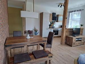 a kitchen and dining room with a wooden table and chairs at Holiday Apartment FeWo III in Reinhardtsdorf +12 photos