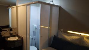 a bathroom with a toilet and a sink at Hotel Aero Sleep Campinas in Campinas