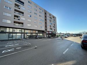 an empty parking lot next to a large building at Apartman Pionir in Sarajevo