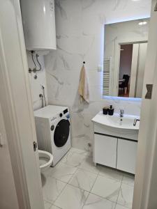 bagno bianco con lavatrice e lavandino di MiS Lux a Mladenovac