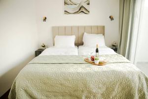 a bed with a tray with a bottle of wine on it at נווה מדבר - צימרים ירוחם in Yeroẖam