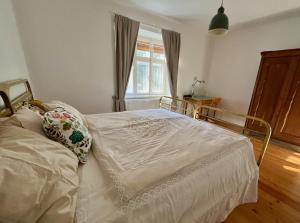 ein weißes Bett in einem Zimmer mit Fenster in der Unterkunft Alte Backstube in Waidhofen an der Thaya