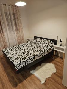 una camera da letto con un letto con copriletto bianco e nero di MiS Lux a Mladenovac
