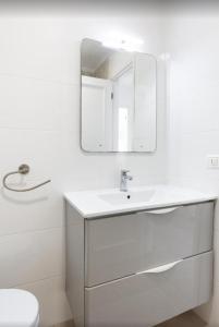 Un baño blanco con lavabo y espejo. en Atardecer 1, en Puerto de Santiago