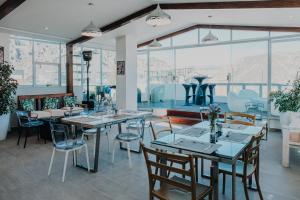a dining room with tables and chairs and windows at Fratelli Apart Hotel in La Paz