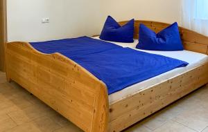 a bedroom with a wooden bed with blue pillows at 2 Bedroom Stunning Home In Arzfeld in Arzfeld