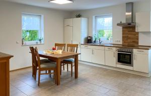 a kitchen with a wooden table and chairs in a kitchen at 2 Bedroom Stunning Home In Arzfeld in Arzfeld