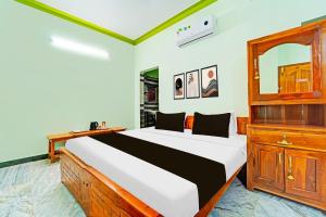 a bedroom with a bed and a dresser and a mirror at Hotel O M.S.MATHAN LODGE in Tirunelveli