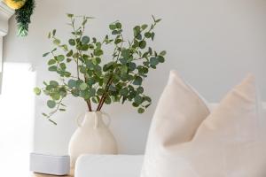 a white vase with a plant in it on a table at Renovated Cape Near Beach with Fire Pit in Fairfield