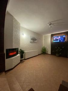 a large room with a fireplace and a tv at Vila Silvana in Moieciu de Jos