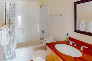 a bathroom with a sink and a tub and a toilet at La Petite Maison in Oceanside +29 photos