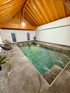 a swimming pool in a room with a wooden ceiling at L ecrin de Rosheim, villa d exception, piscine in Rosheim