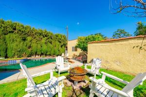 a group of white chairs sitting next to a swimming pool at Pool Spa Games Peaceful Garden Retreat in Glendale