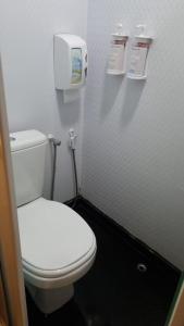 a bathroom with a white toilet and a paper dispenser at Hotel Aero Sleep Campinas in Campinas