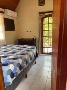 a bedroom with a bed in a room with a window at Kasa util in Gravatá