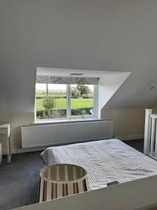 a bedroom with a bed and a large window at Studio Apartment with games room in Royal Wootton Bassett