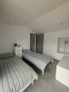 two beds in a room with white walls at Gîte Ferrari 07 Ruoms in Ruoms +15 photos