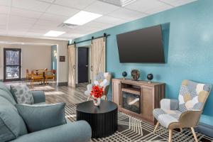 a living room with a tv and a couch and chairs at Best Western Plus Richmond Indiana I-70 in Richmond