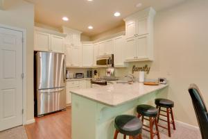 a kitchen with white cabinets and a kitchen island with stools at Half-Mi to Big Boulder Lake Townhome with Deck! in Lake Harmony