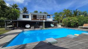 a house with a swimming pool in front of a house at La Baie des Mangues 1 - Baba Figue - Nibou in Saint-Paul