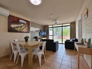ein Wohnzimmer mit Tisch und Couch in der Unterkunft Riverview Holiday Apartment 60 - Kalbarri WA in Kalbarri