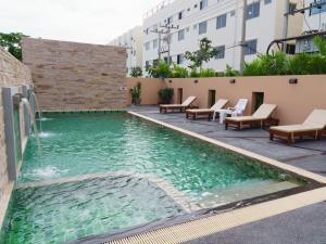 a swimming pool with a fountain in the middle of a building at VISA Hotel Hua Hin - SHA Plus in Hua Hin