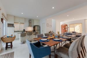 a dining room and living room with a table and chairs at Casa Acalan in Puerto Morelos
