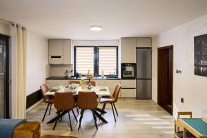 a kitchen and dining room with a table and chairs at Holiday House Papuk in Novo Zvecevo