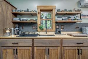 a kitchen with wooden cabinets and a sink and a window at Upscale w Fireplace Fire Pit Games in Gated Comm in Paw Paw