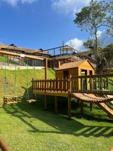 a wooden playground with a house and a swing at Bangalô com 3 suítes no Eco Resort na Praia dos Carneiros in Tamandaré