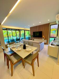 a living room with a table and a couch at Bangalô com 3 suítes no Eco Resort na Praia dos Carneiros in Tamandaré