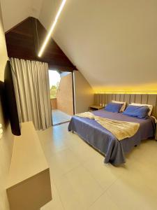 a bedroom with a bed with blue pillows on it at Bangalô com 3 suítes no Eco Resort na Praia dos Carneiros in Tamandaré +35 photos