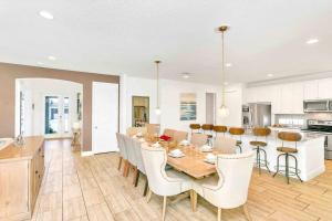 a kitchen and dining room with a table and chairs at SUPER SIZE - 11BDr SPACiOUS HOME w POOL & HOT TUB in Kissimmee