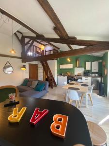 a living room with a table and a kitchen at Le Nid Paisible in Verdun