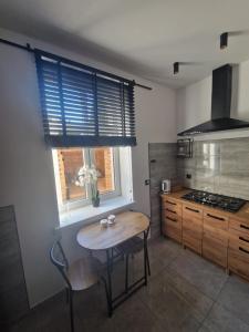 a kitchen with a wooden table and a window at Apartament Zacisze 2 in Przemyśl +16 photos
